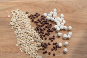 marshmallows, chocolate chips and oats on a cutting board