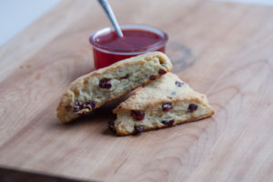 orange cranberry scones with jam on a cutting board