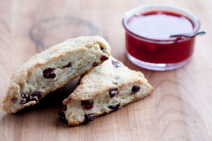 orange cranberry scones with jam on a cutting board close-up
