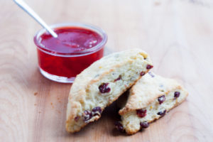 orange cranberry scones with jam in a bowl with spoon