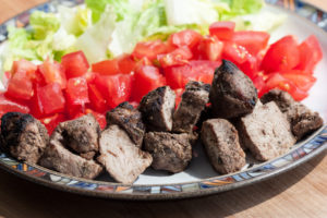 jerk pork with tomatoes and lettuce on a plate