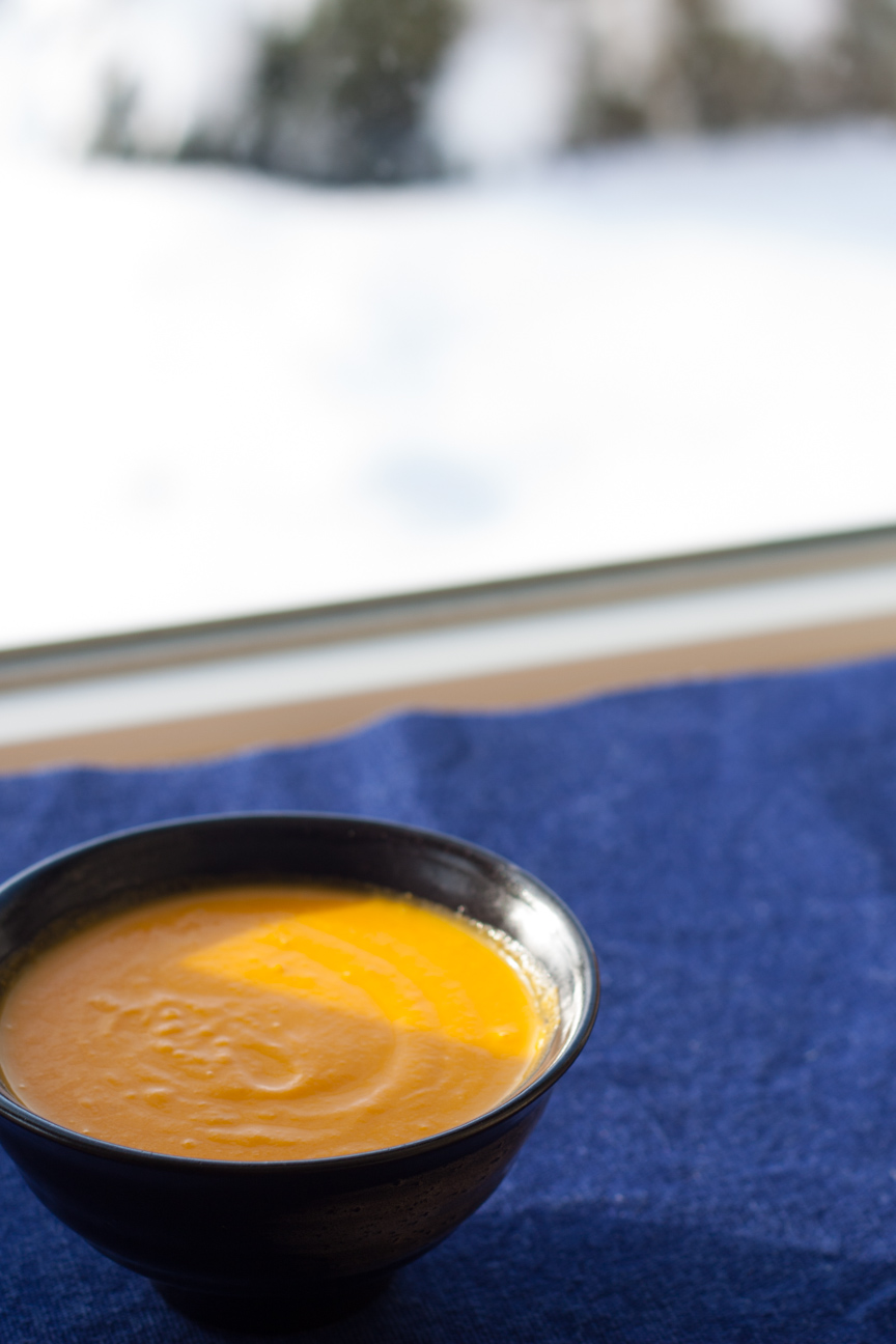 carrot lemon soup in bowl on blue napkin