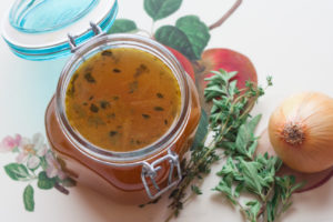 vegetable stock in a jar with fresh herbs