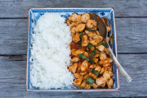 thai chicken with chilies and basil with rice on a plate