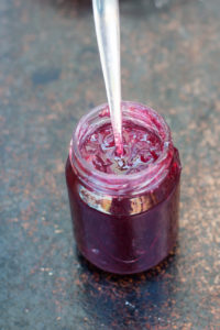 red gooseberry elderflower jam in a jar