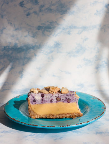 slice of blueberry mango ice cream cake on blue plate