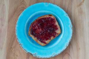 Honey Butter Whole Wheat Bread with jam on blue plate