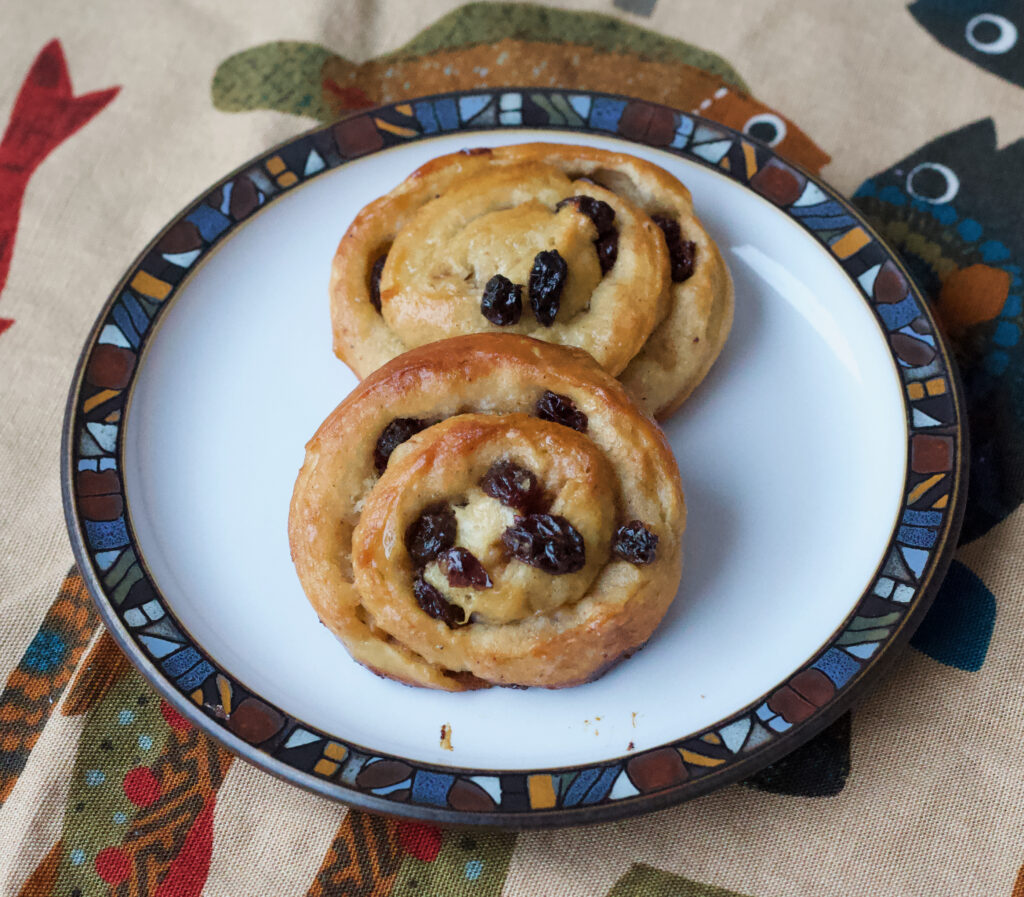 two apple cider pain au raisin on a plate