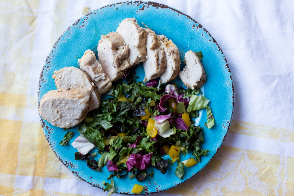 chicken and salad on a blue plate