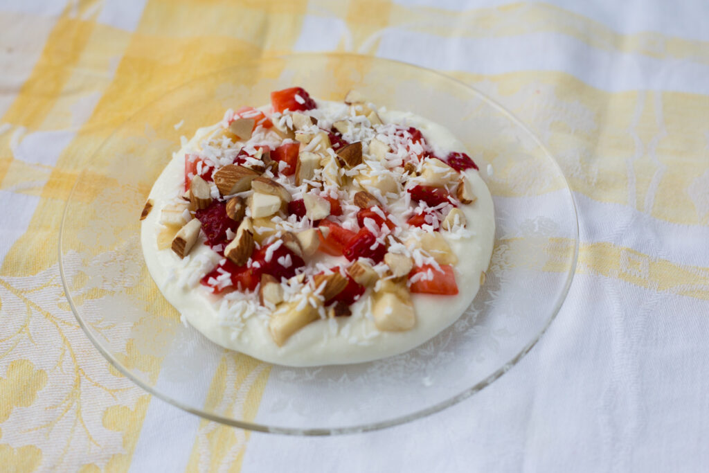 ashta on a glass plate with nuts and fruit on top