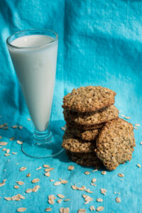 a stack of oatmeal cookies with a glass of milk